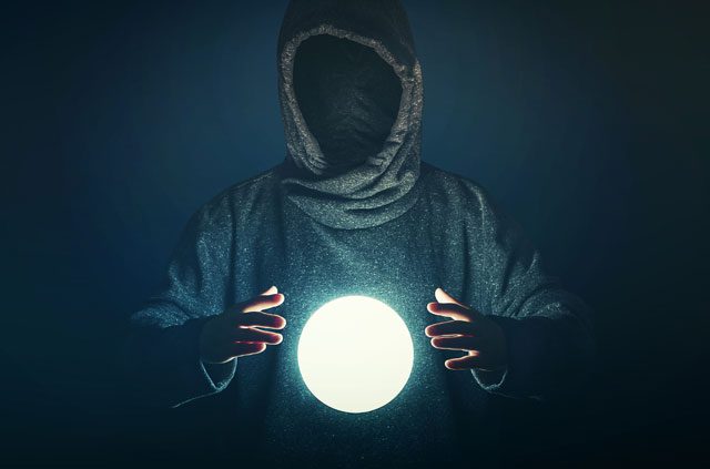 A mysterious, shrouded figure observes a glowing orb.