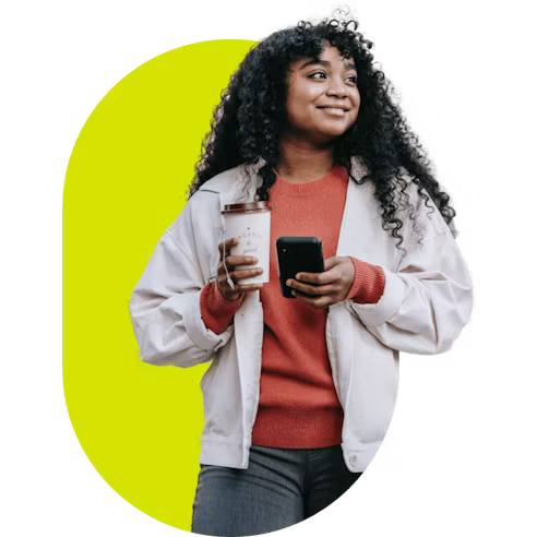 Personne qui tient un téléphone et une tasse de café.